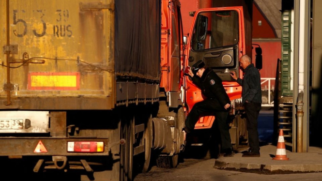 Penjaga memeriksa truk di titik perlintasan Rusia dengan Lithuania.