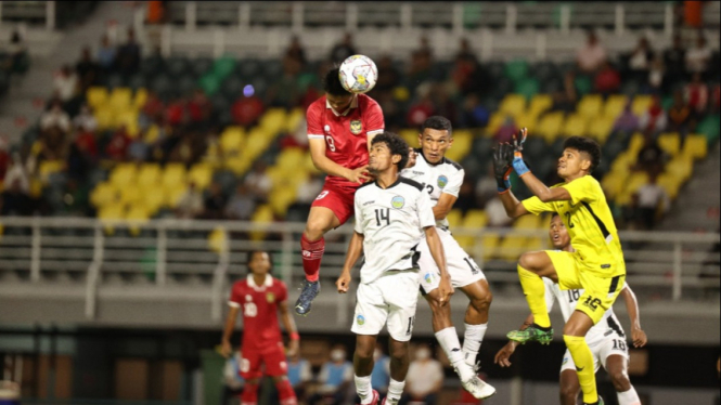 Hokky Caraka Berebut Bola dengan Pemain Timor Leste