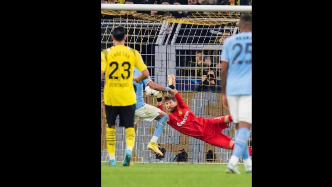 Kiper Gregor Kobel (Dortmund) menahan tendangan penalti Mahrez