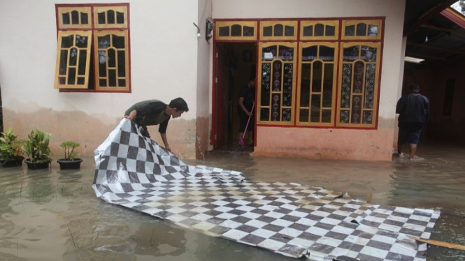 Warga membersihkan rumahnya di Jorong Kampung Baru pasca banjir